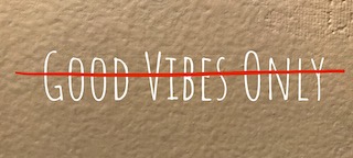 wall with good vibes only written and crossed out in red ink