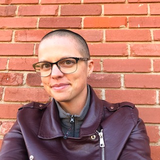 image of KaDee standing in front of a brick wall