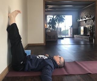 person lying on floor with legs resting against wall