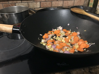 wok containing aromatics on the stove