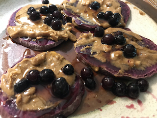 purple sweet potato pancakes topped with blueberries and peanut butter