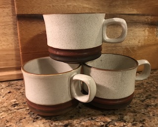 an image of three ceramic coffee mugs stacked in a pyramid formation