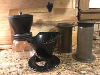 a coffee grinder, pour over cone, and aeropress